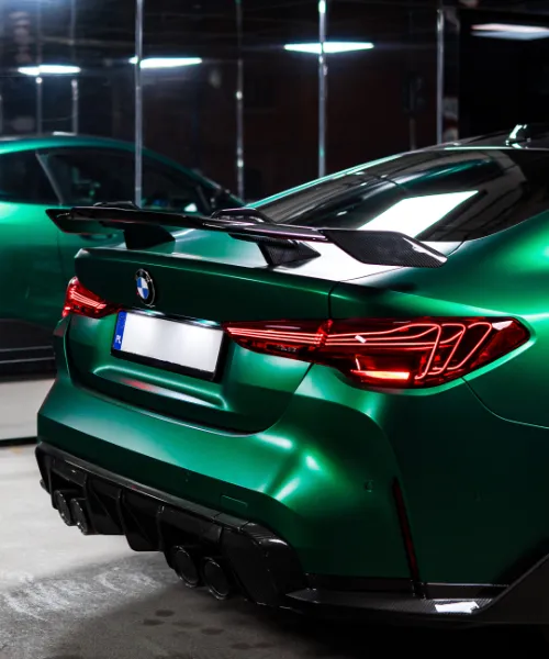 Zbliżenie na tylny zderzak sportowego samochodu ze spoilerem na klapie bagażnika.